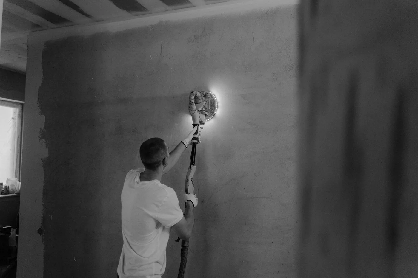 Broušení stěny bruskou při renovaci
