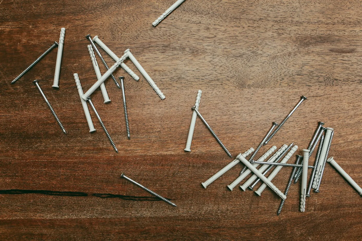 Rozházené hmoždinky a šrouby na pracovním stole
