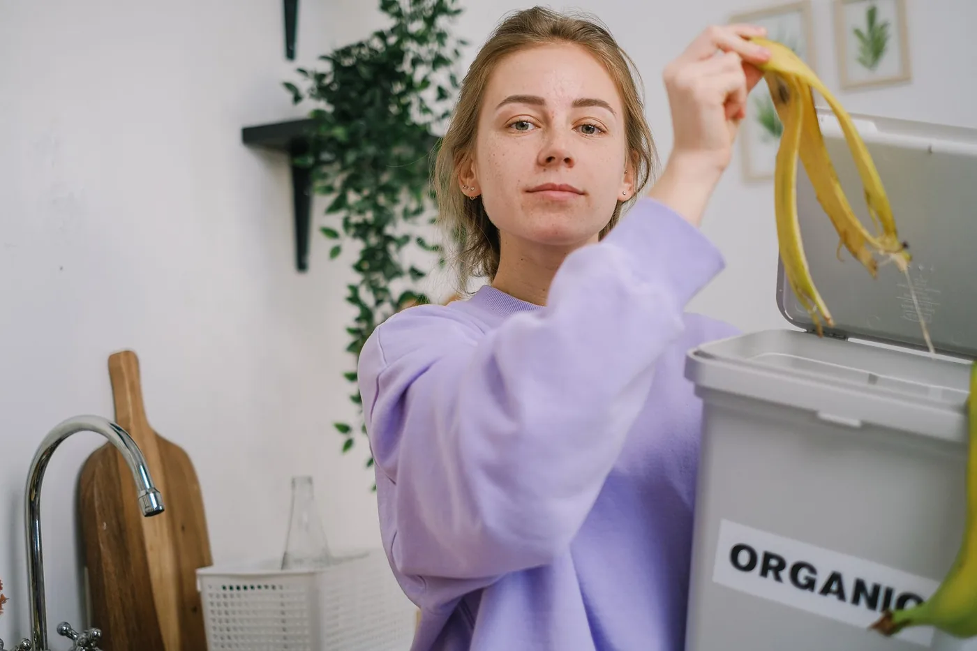Žena třídí bioodpad do koše v kuchyni