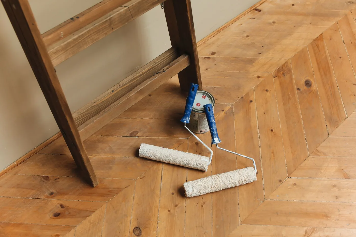 plechovka a válečky na dřevěné podlaze