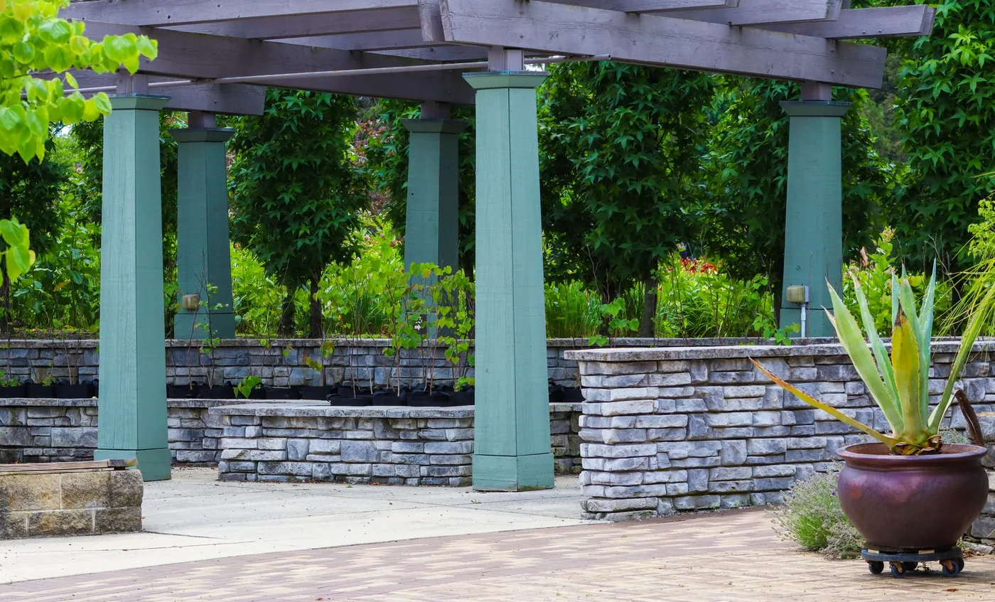 zahradní pergola s kamennými záhony a zelení