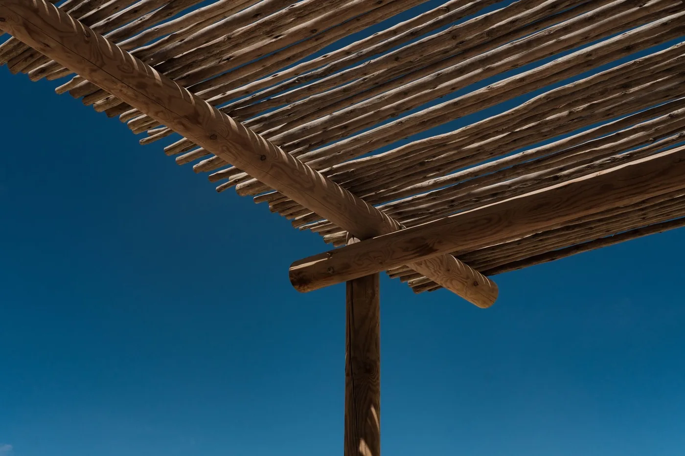 detail dřevěné konstrukce pergoly proti obloze
