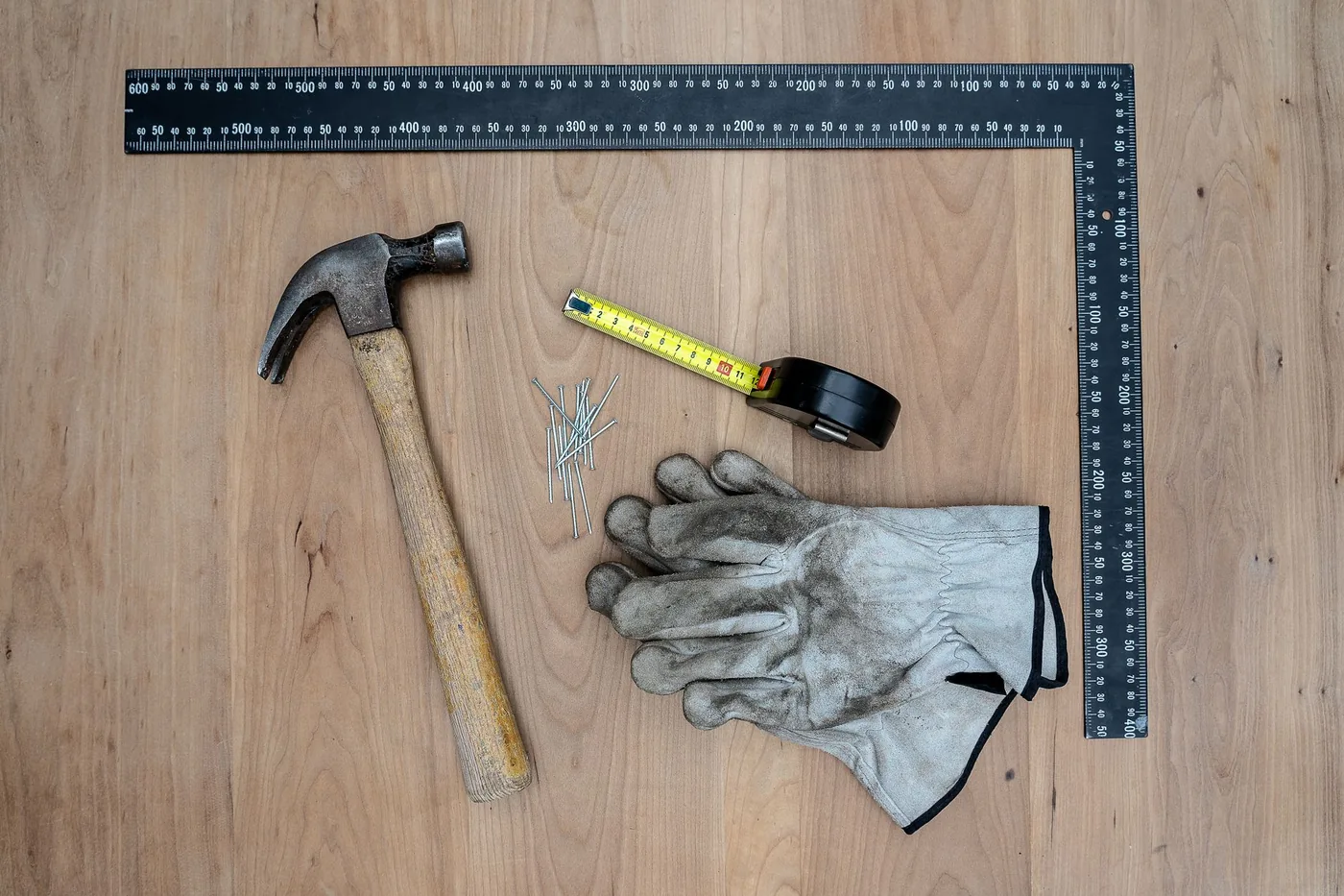 kladivo, metr, hřebíky a rukavice