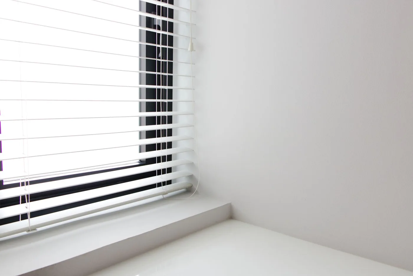 Bílé horizontální žaluzie v minimalistickém interiéru