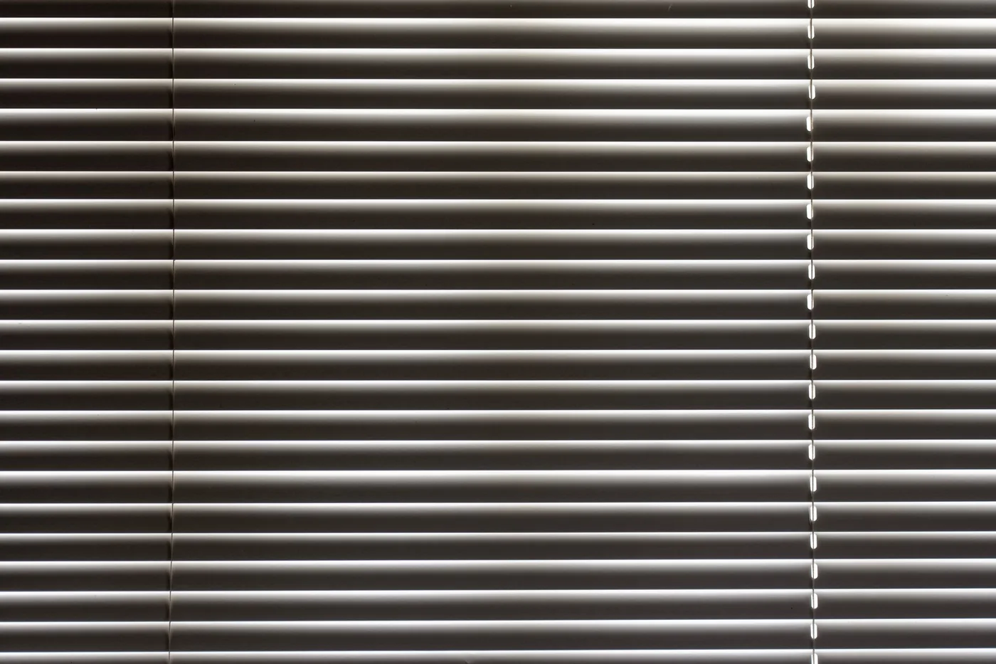 Detail lesklých kovových horizontálních žaluzií